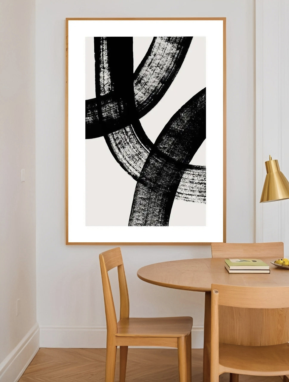 Dining room with abstract black and white artwork on the wall, wooden table, and chairs.