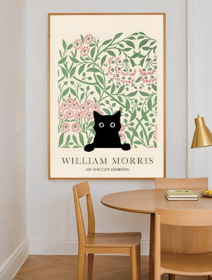 Framed artwork with a black cat art print with floral design on a wall above a wooden table.
