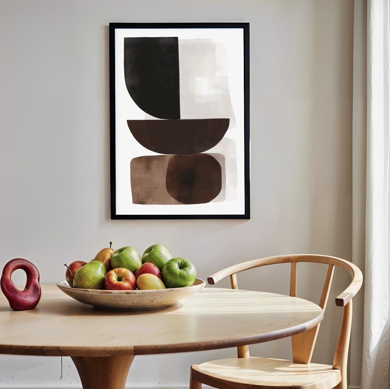 Abstract art print on a wall above a table with fruit and a chair.