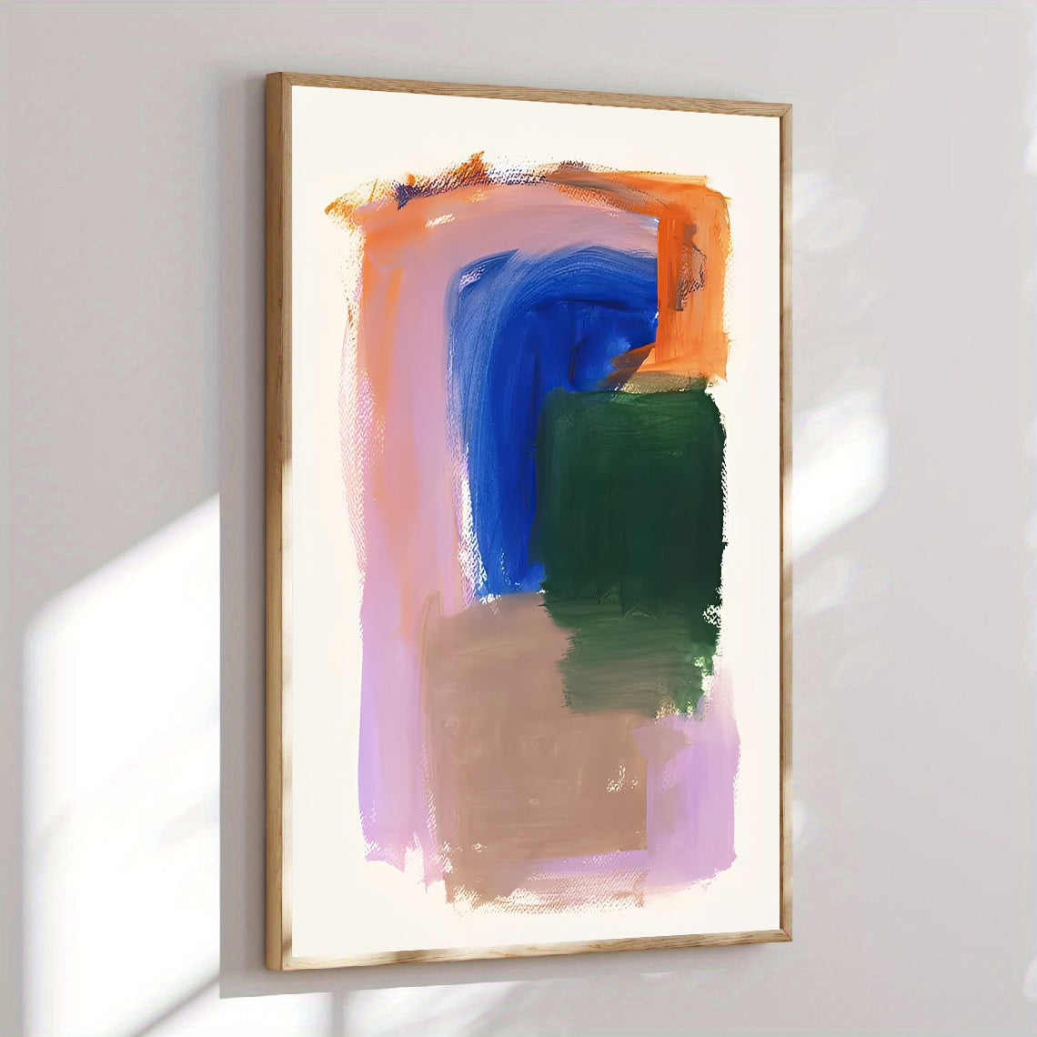 Abstract painting with colorful brush strokes in a gold frame on a white wall