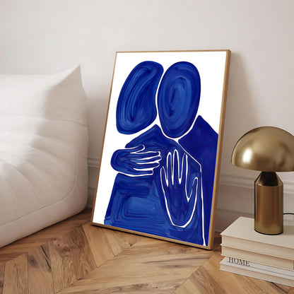 Abstract art print with blue and white design in a gold frame on a wooden floor.